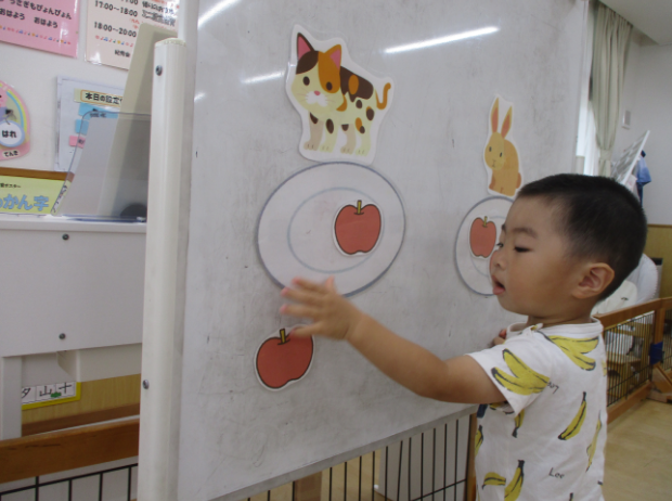 ホワイトボードで遊ぶ園児