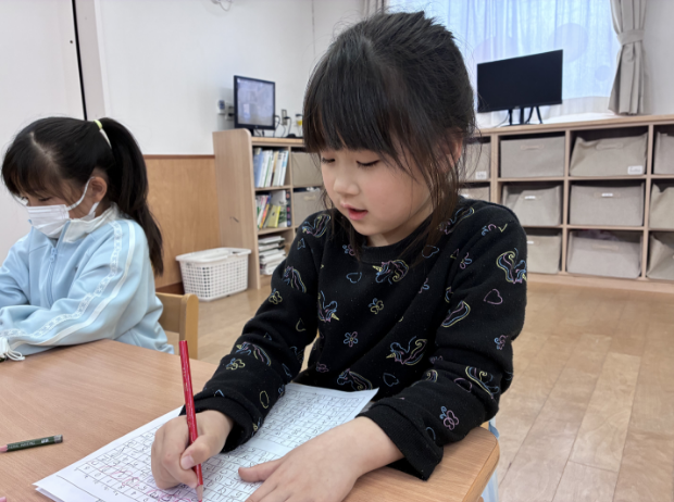 書き方の練習をする園児