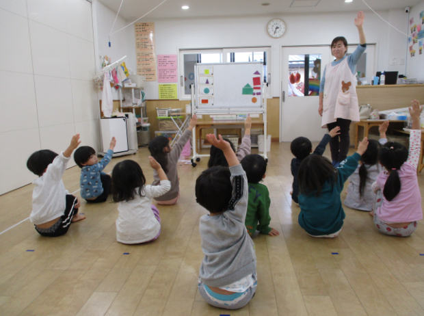 先生と手遊びをする園児たち